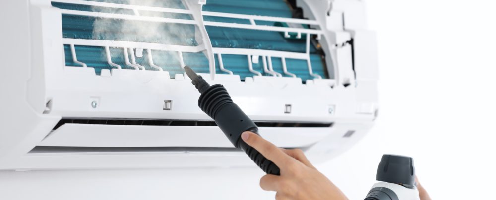 Technician cleaning air conditioner indoors