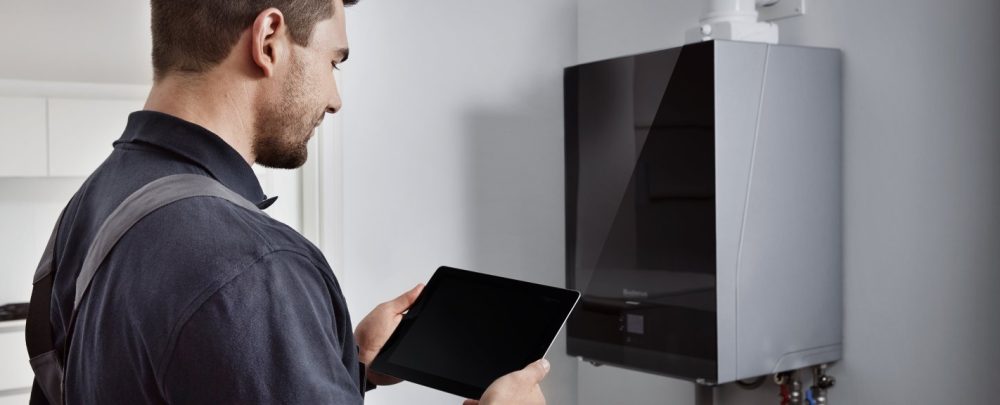 man_with_tablet_in_front_of_buderus_boiler_305478_1440x576